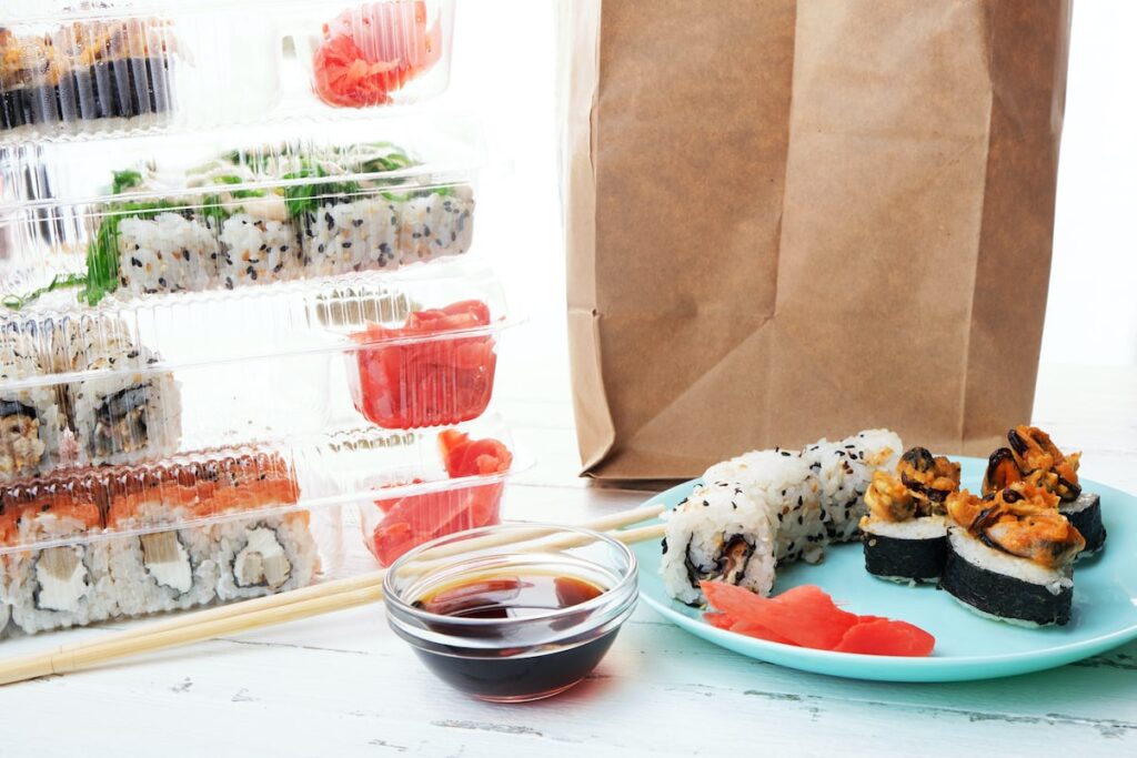 takeaway sushi dish with boxes and side of soy sauce